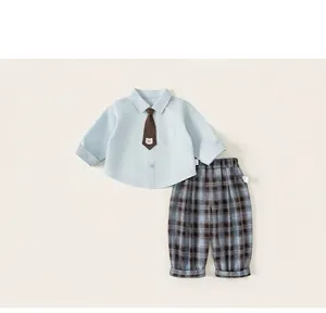 Detail of boys' light blue shirt with bear embroidery tie and plaid trousers outfit