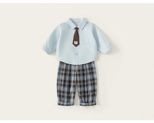 Detail of boys plaid trousers and light blue shirt with bear embroidered necktie