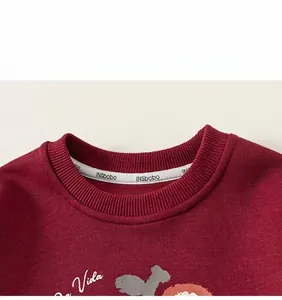 Detail van de bordeauxrode sweatshirt-halslijn met ribboord en de Vida-opdruk