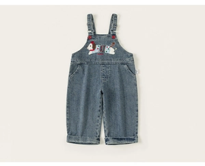 Detailed close-up of a blue denim overall featuring a cute cartoon dog embroidery patch