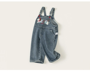Detail showing blue denim overalls with cartoon dog embroidery and brand label