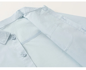 Detailed macro view of the light blue shirt collar with high-quality resin buttons and stitching