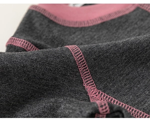 Detail of grey knit fabric with pink contrast stitching and ribbed neckline
