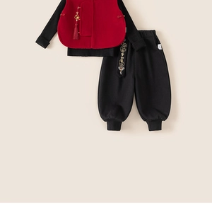 Detail of red festive vest and trousers with traditional embroidery and tassels