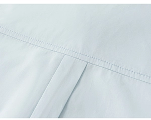 Detailed macro view of light blue shirt fabric showing fine double stitching and pleats