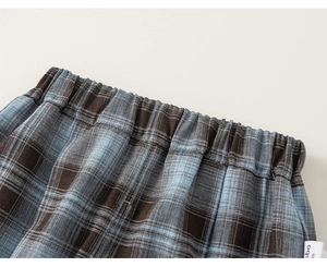 Macro detail of elastic waistband on blue and brown plaid fabric shorts for boys