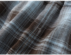 Detailed macro view of the premium blue and brown plaid woven fabric for boy's suit