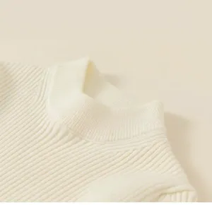 Detailed view of cream knit sweater showing ribbed texture and classic crew neck