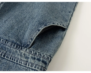 Detailed close-up of blue denim fabric with visible twill texture and double stitching
