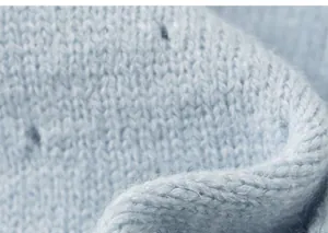 Close-up of soft light blue knit texture showing delicate fibers and weave for children