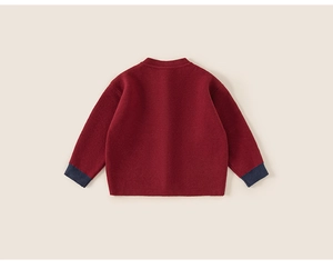 Detailweergave van de achterkant van de gebreide kindertrui in rood met blauwe boorden