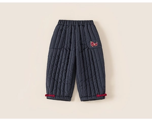 Detail van de marineblauwe gewatteerde kinderbroek met borduursel en rode trekkoorden