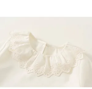 Close-up of girls' white shirt featuring a delicate lace embroidered scalloped collar