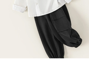 Detailed flat lay of white button-down shirt and black cargo joggers for boys