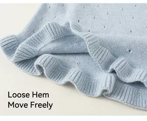 Detailed macro view of light blue knitted vest with hollow patterns and wavy hem