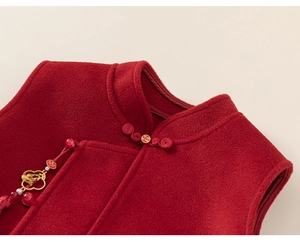 Detail of red Chinese New Year vest showing mandarin collar with golden floral metal charm