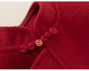 Détail du gilet rouge chinois traditionnel avec bouton brodé et boucle dorée