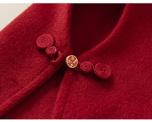 Détail de la cape en laine rouge avec bouton chinois traditionnel et boucle dorée gravée