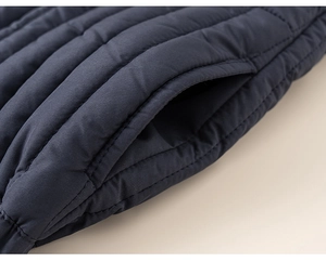 Detailweergave van de donkerblauwe gewatteerde winterjas met stiksels en zijzak