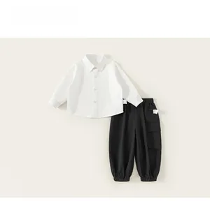 Detail of boys white cotton shirt and black cargo pants set with elastic waist and pockets