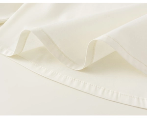 Close-up of dual-line stitching on the hem of a white knitted vest for girls
