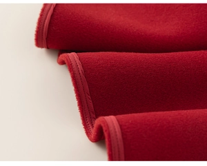 Gros plan sur le tissu en velours rouge épais avec coutures nettes d'un gilet d'hiver