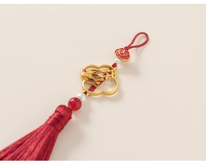 Détail d'un nœud traditionnel chinois rouge et doré avec pompons et motifs d'oiseaux
