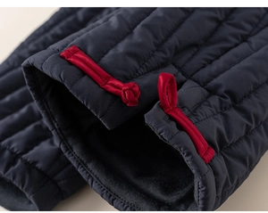 Detailopname van marineblauwe gewatteerde stof met traditionele rode Chinese knoopsluitingen