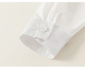 Close-up of white shirt sleeve cuff with button and clean stitching detail