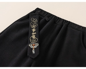 Detail of kids black pants elastic waist with gold embroidered Chinese blessing ribbon