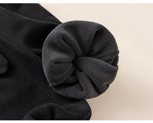 Detail view of children's thick fleece lining and durable stitching on black winter trousers