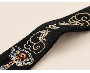 Detailed close-up of Chinese embroidery with auspicious clouds on the black fabric set