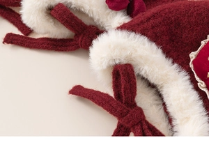 Détail du bonnet d'hiver rouge avec bordure en peluche et nœud en velours élégant