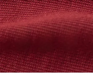 Gros plan du bonnet rouge en maille montrant la texture douce et sûre du tissu tricoté
