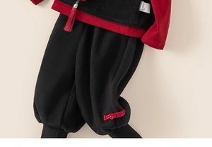 Detailed shot of traditional Chinese kids' suit with red tassels and exquisite knot buttons