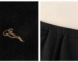 Detail of children's black knitted trousers with elastic waistband and Fu embroidery