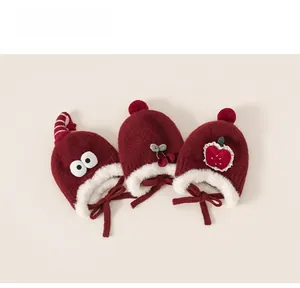 Détail de bonnets d'hiver rouges tricotés pour bébé avec doublure douce et cerises