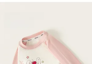 Detail of a kids' long-sleeve T-shirt featuring a cartoon bunny and cherry print design