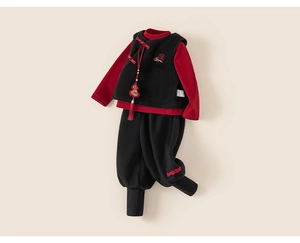 Detailed view of children's New Year outfit with gold embroidery and red tassels