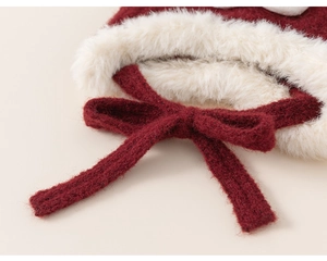 Détail du bonnet rouge tricoté épais avec fourrure blanche moelleuse et nœud rouge