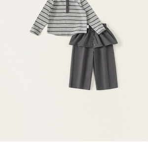 Detail of grey striped long sleeve hoodie and dark trousers with decorative waist ruffle