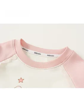 Detail of pink cotton girl's top with white lace trim on sleeves and raglan neckline