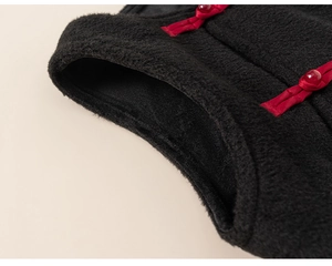 Detailed macro view of black fleece fabric with red traditional Chinese knot buttons
