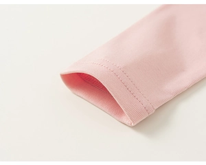 Detail of pink long sleeve shirt showing ribbed cuff and reinforced double stitching