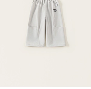 Detail view of light grey kids wide-leg cargo pants with elastic waist and stylish badge