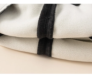Close-up detail of soft white fleece lining with black stitched edging for children clothing