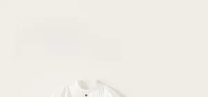 Detailed view of kids white shirt with ruffled collar and pleated cotton fabric texture