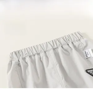 Detailed close-up of elastic waistband with brand tag on kids grey cargo pants