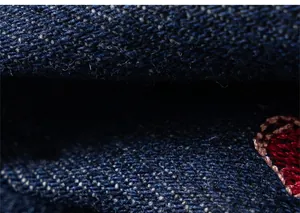 Gros plan sur le denim bleu foncé avec détails de broderie de haute qualité et texture
