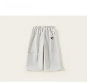 Detail view of children's wide-leg cargo pants with elastic waist and rubber badge